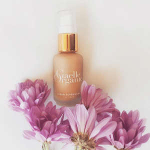 Sérum Graelle Organic entouré de fleurs, utilisé dans les soins visage ONA à l'Institut de beauté d'Alfortville, France.